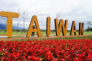 A person standing with letters that spell Taiwan.
