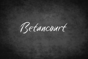 The last name Betancourt is written in chalk on a chalkboard.