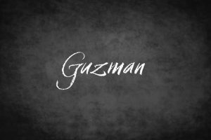 Le nom de famille Guzman écrit sur un tableau noir.