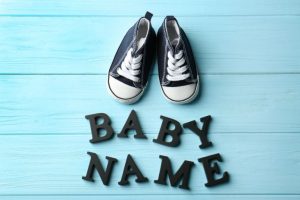 Zapatos de bebé en una mesa con las palabras Nombre del bebé.